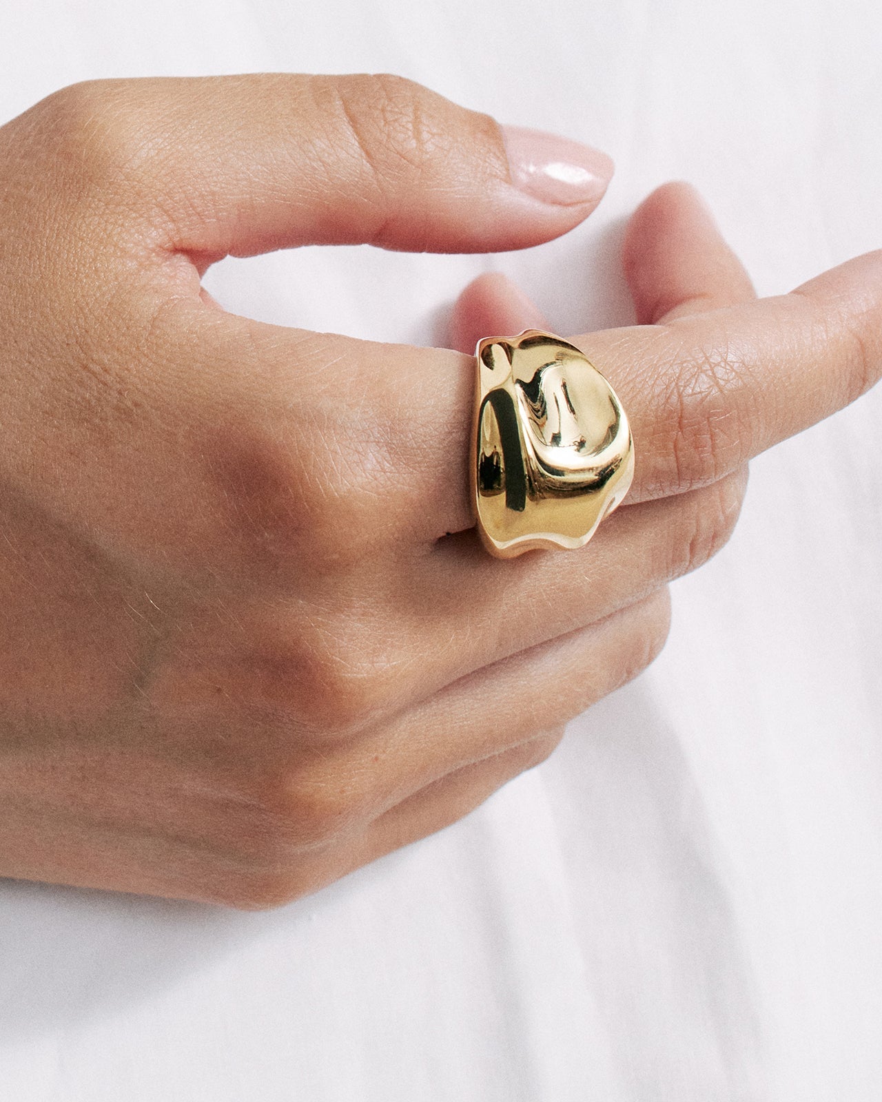 Gold vermeil dome ring with a reflective sculptural design, worn on the index finger