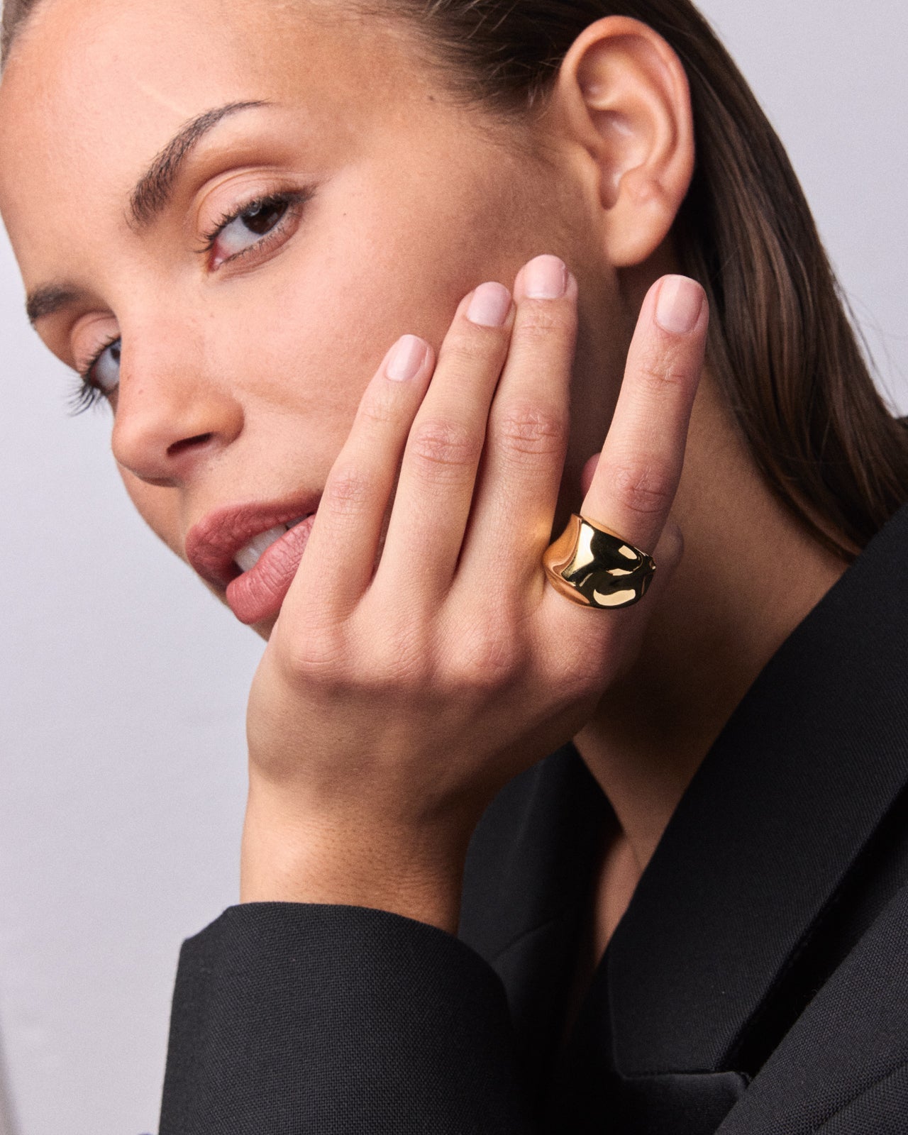 Sculptural gold vermeil dome ring with a smooth reflective finish on the index finger