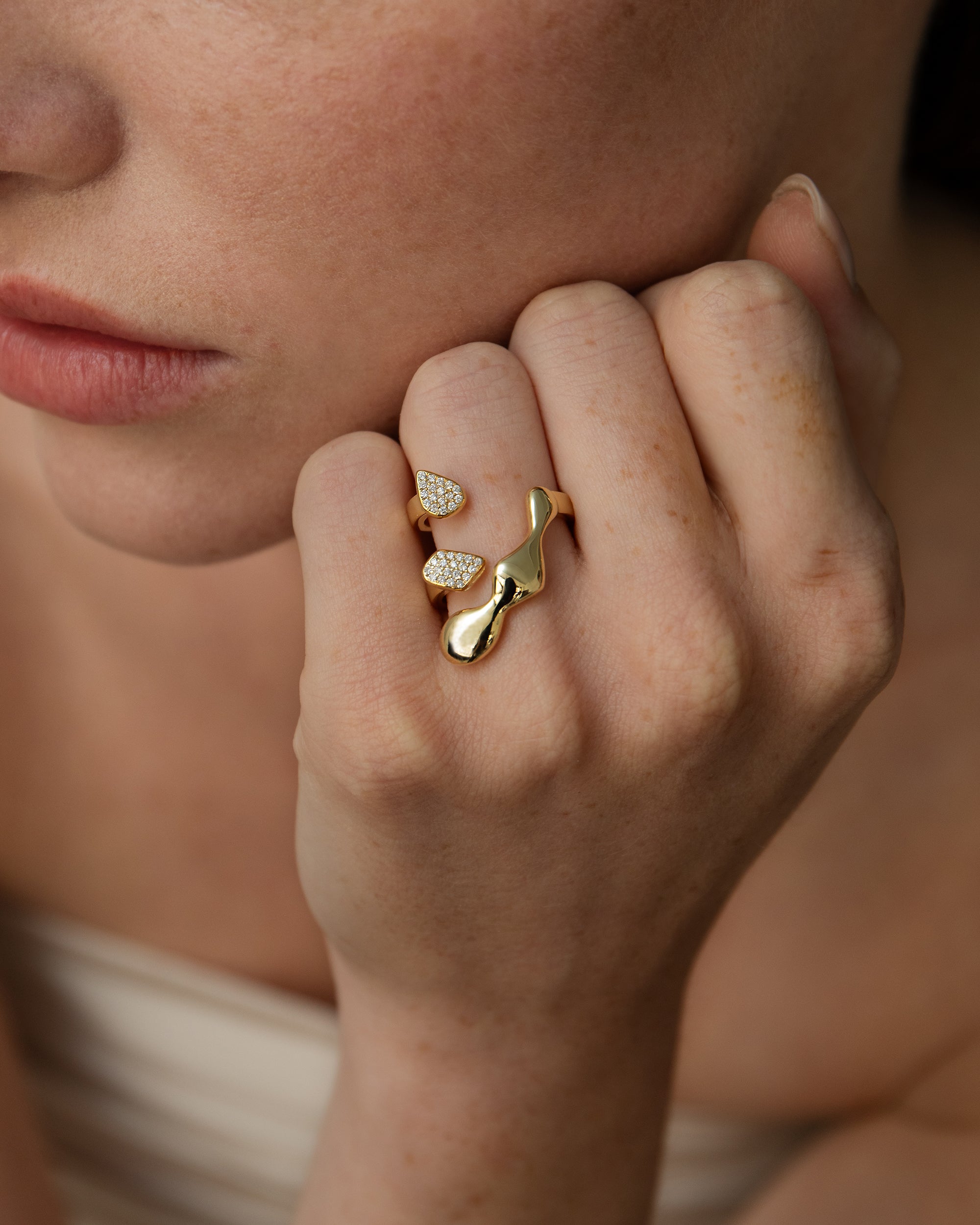 A person's hand wearing Flux 18K Gold Ring with pave diamonds on a finger.