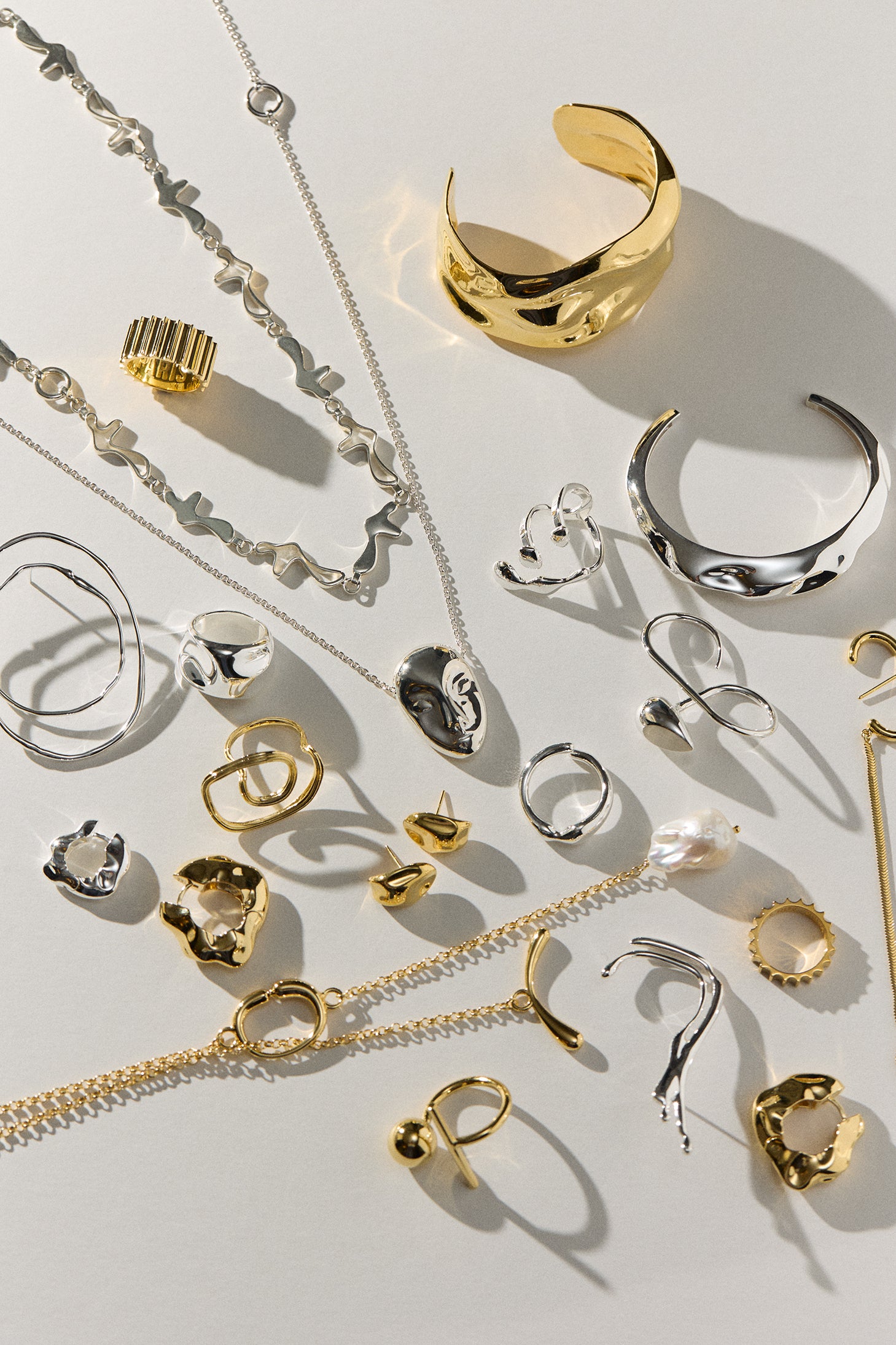 Collection of gold and silver jewelry on a light background